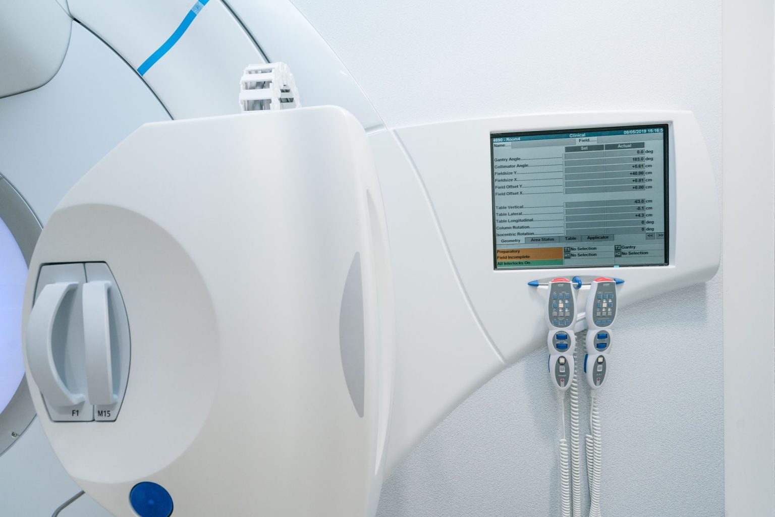 Equipamento moderno de radioterapia com painel de controle e tela em uma sala clínica hospitalar.